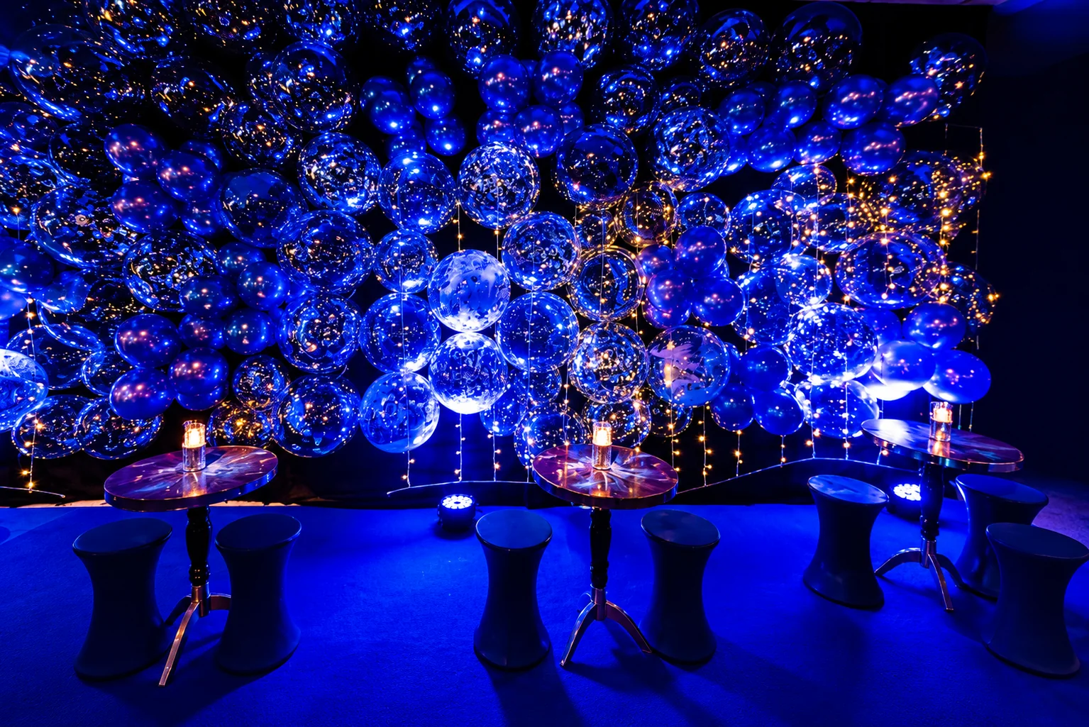 Decoração com balões transparentes e iluminação azul em evento no Espaço Zeus