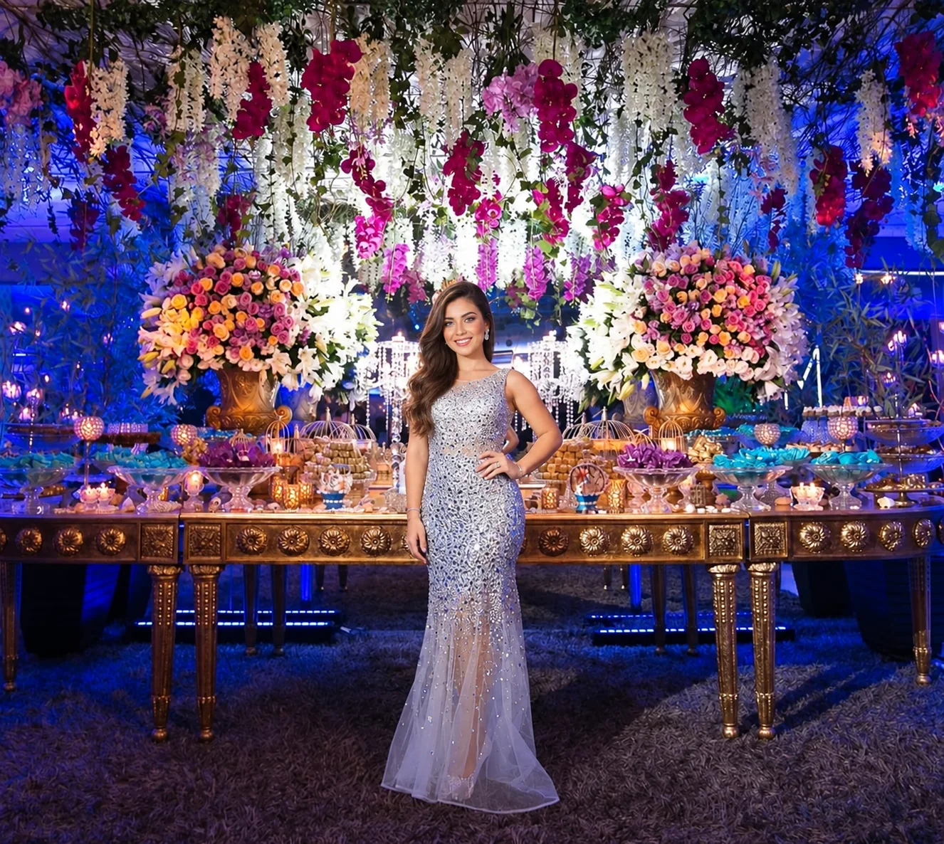 Festa de 15 anos no Espaço Zeus com debutante diante de uma mesa floral iluminada